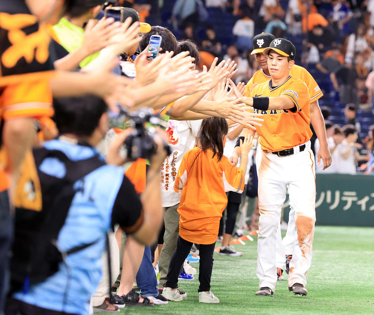 巨人対中日　場内1周でファンとハイタッチする門脇とメンデス（撮影・浅見桂子）