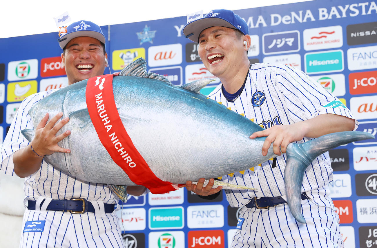 DeNA対ヤクルト　お立ち台でマグロを贈呈されたDeNA浜口（左）と佐野は笑顔でおどける（撮影・垰建太）