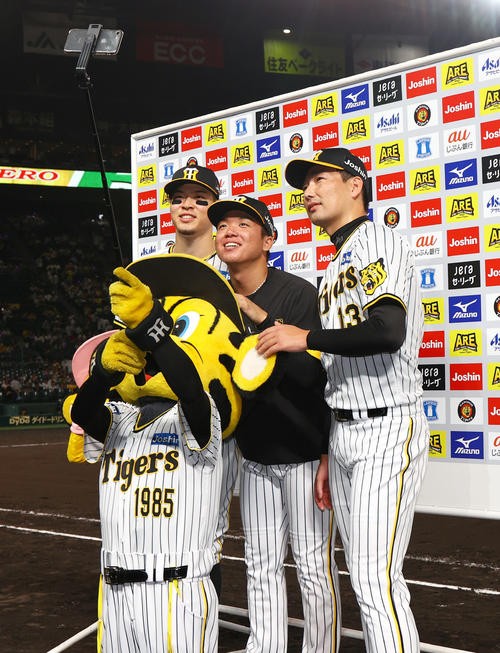 9月8日、阪神対広島 ヒーローインタビューを終え、お立ち台で記念撮影する、左から佐藤輝、村上、岩崎(撮影・上山淳一)