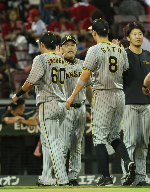 8月16日、広島対阪神　広島に勝ちマジック29を点灯させた岡田監督（中央）は、小野寺（左）と佐藤輝を迎える。右端は岩貞（撮影・加藤孝規）