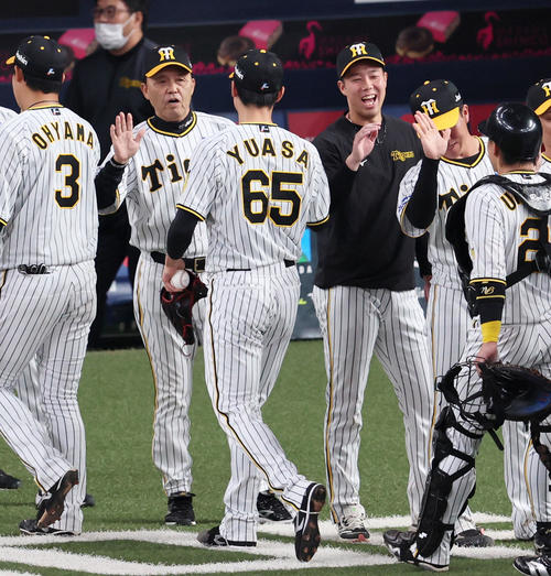 3月31日、阪神対DeNA　岡田監督（左から2人目）は開幕戦を勝利し湯浅らナインを出迎える。右は青柳（撮影・加藤哉）