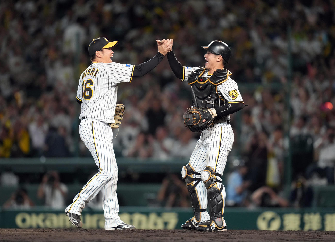 阪神対巨人　試合後、力強くハイタッチを交わす西勇（左）と坂本（撮影・狩俣裕三）