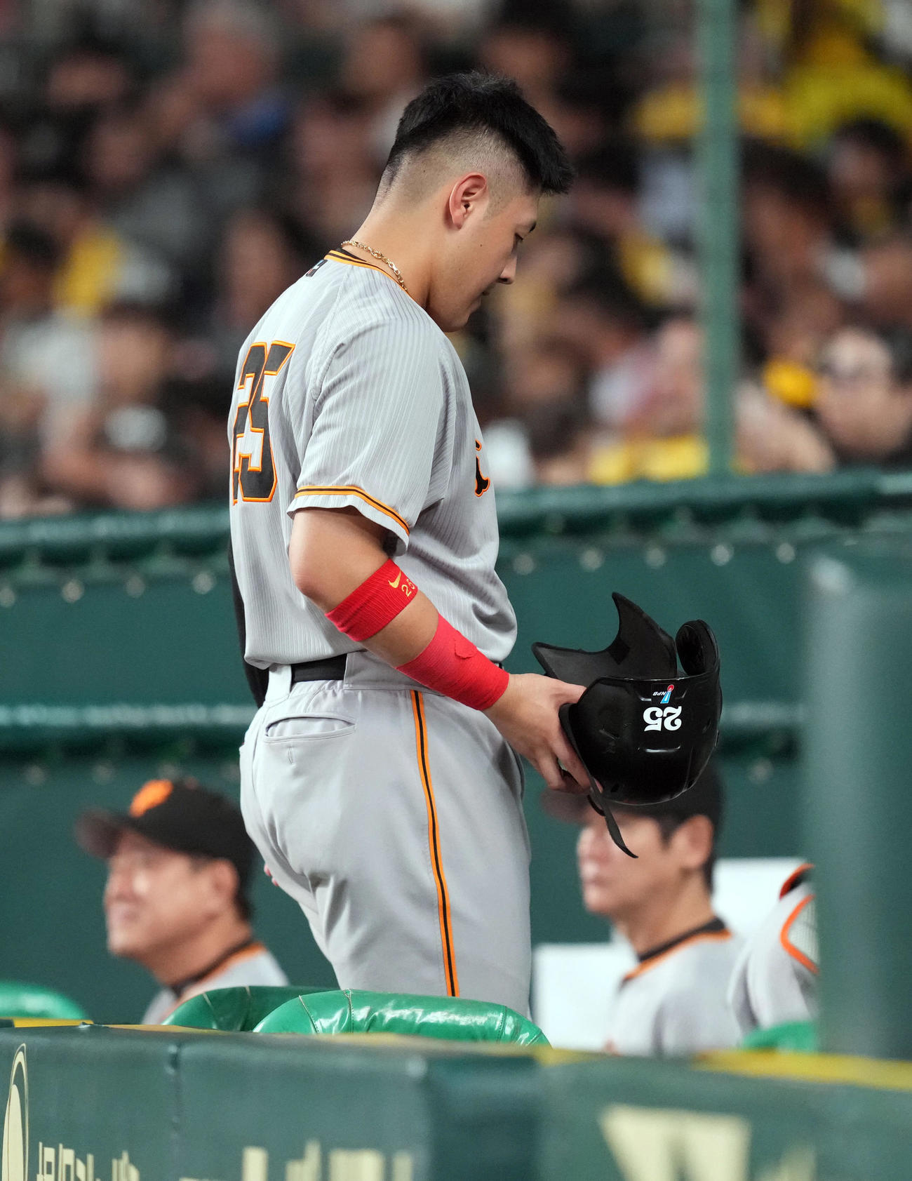 阪神対巨人　7回表巨人2死一塁、二ゴロにベンチに引き揚げる岡本和。後方左は原監督（撮影・狩俣裕三）