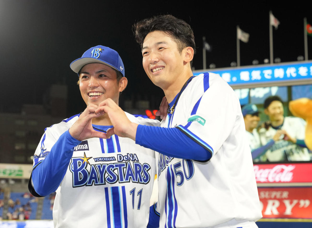 8月24日、11勝目を挙げ、記念撮影でファンのリクエストで山本（右）とハートを作る東