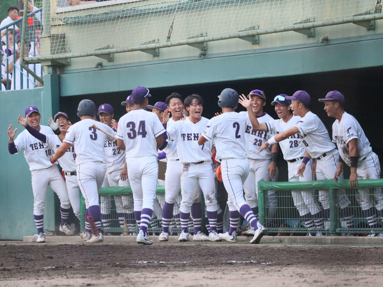 阪神大学野球連盟秋季リーグ戦　天理大対大阪電通大　4回、2ランを放った5番近藤遼一内野手と一走の石飛智外野手を迎える天理大ナイン（撮影・村松万里子）