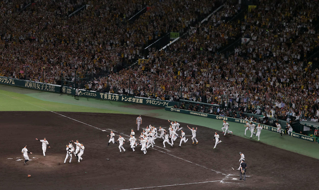 阪神対巨人　18年ぶりにセ・リーグを制覇し、マウンドに向かって駆けだし歓喜する阪神ナイン（撮影・前田充）