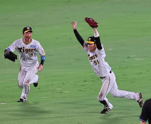阪神対巨人 ウイニングボールを捕球した中野はバンザイしながらマウンドへ走り出す。左は近本(撮影・上田博志)