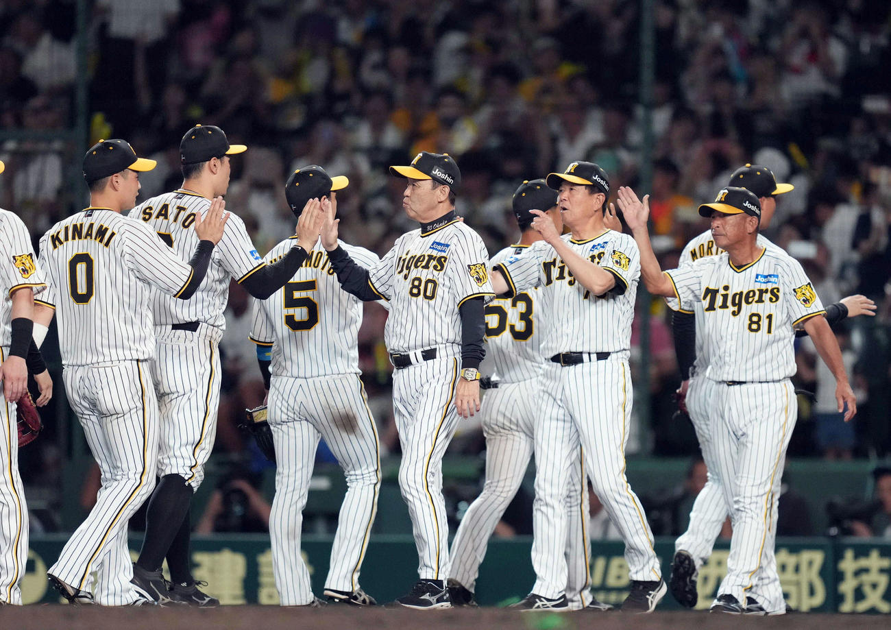 阪神対巨人　試合終了後、佐藤輝（左から2人目）ら選手を迎える岡田監督（中央）（撮影・狩俣裕三）