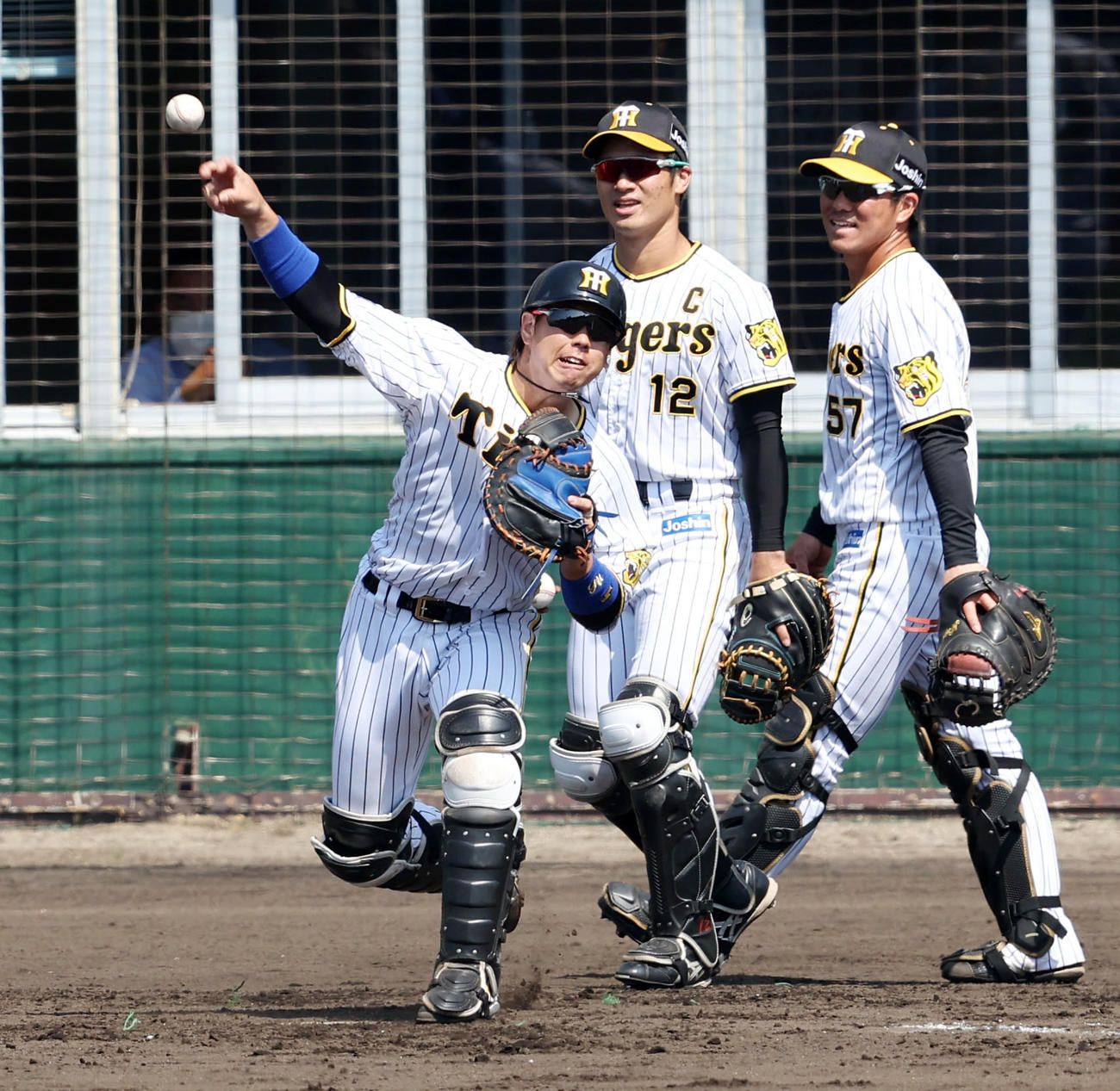 シートノックで二塁へ送球する梅野。中央は坂本、右は長坂（撮影・加藤哉）
