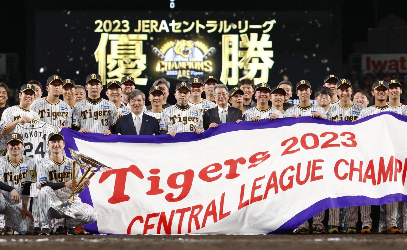プロ野球セ・リーグで18年ぶりに優勝を決め、記念写真に納まる阪神ナインら。手前中央は岡田監督（共同）