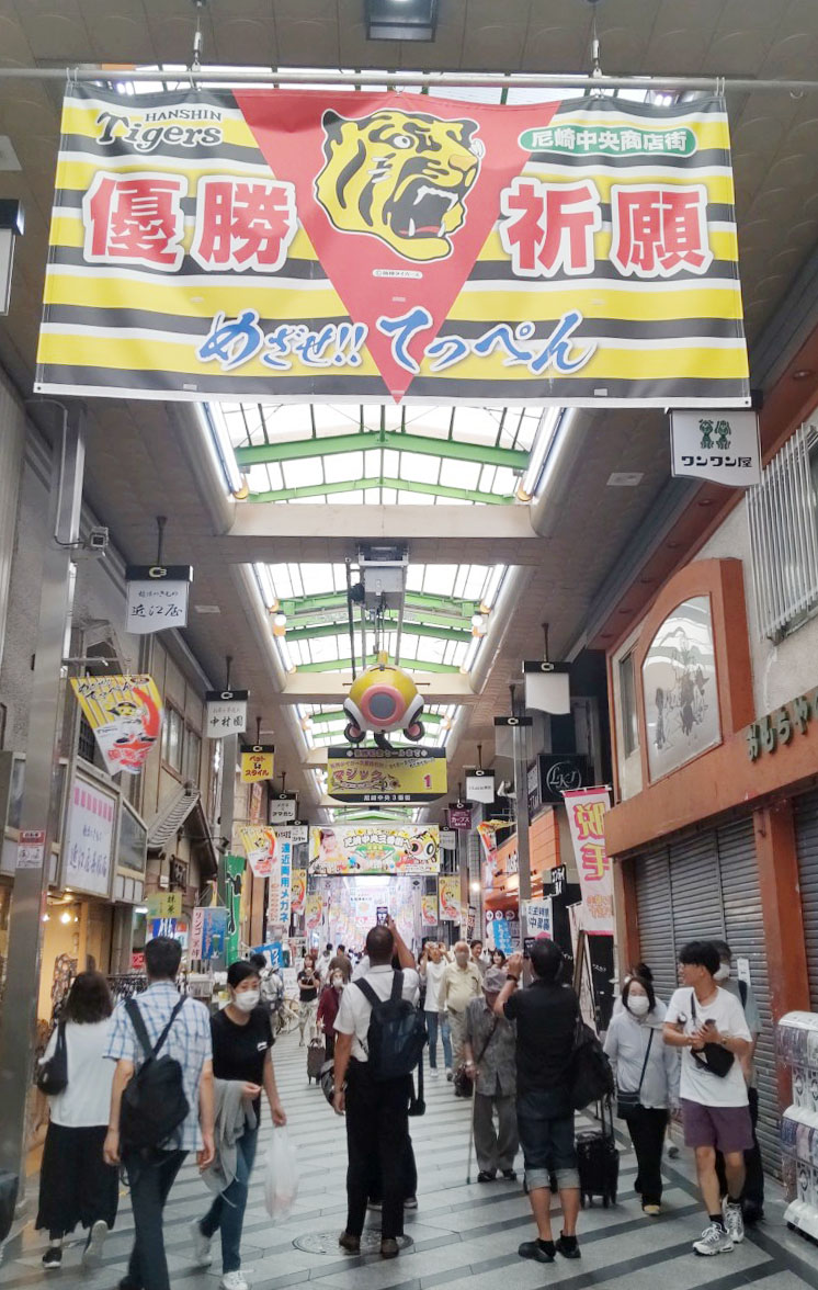甲子園球場の近くにある尼崎中央商店街では、マジック1のボードを撮影するために人々が足を止めていた（撮影・狩俣裕三）