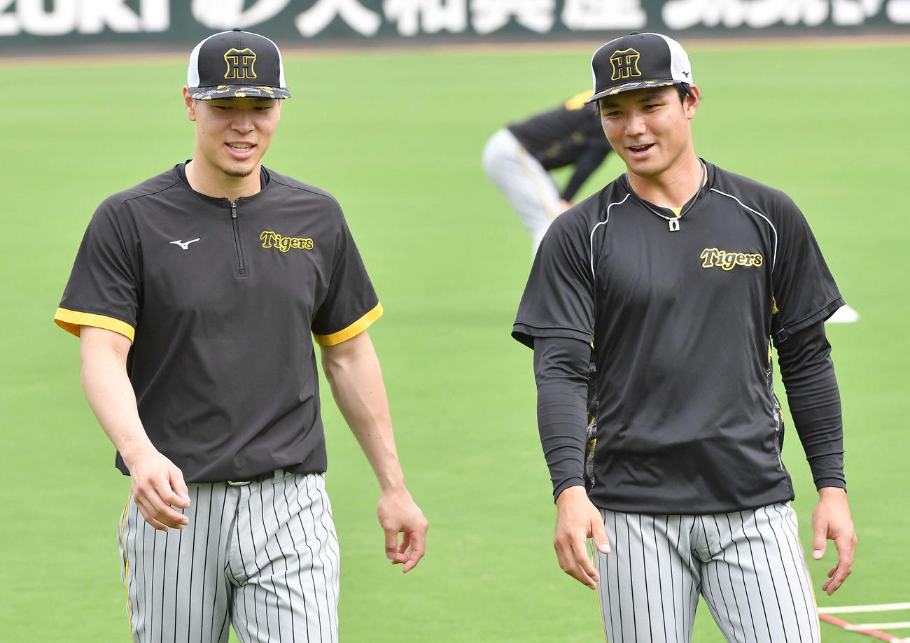 阪神栄枝裕貴（右）と談笑する佐藤輝明（2023年8月撮影）