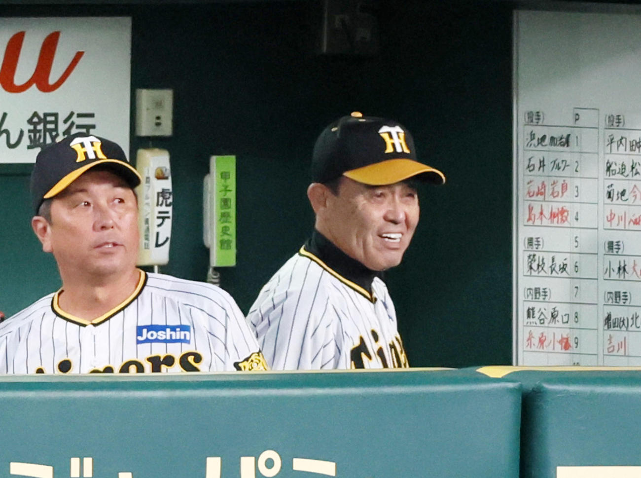 阪神対巨人　1回裏を終えベンチで白い歯を見せる岡田監督（撮影・加藤哉）