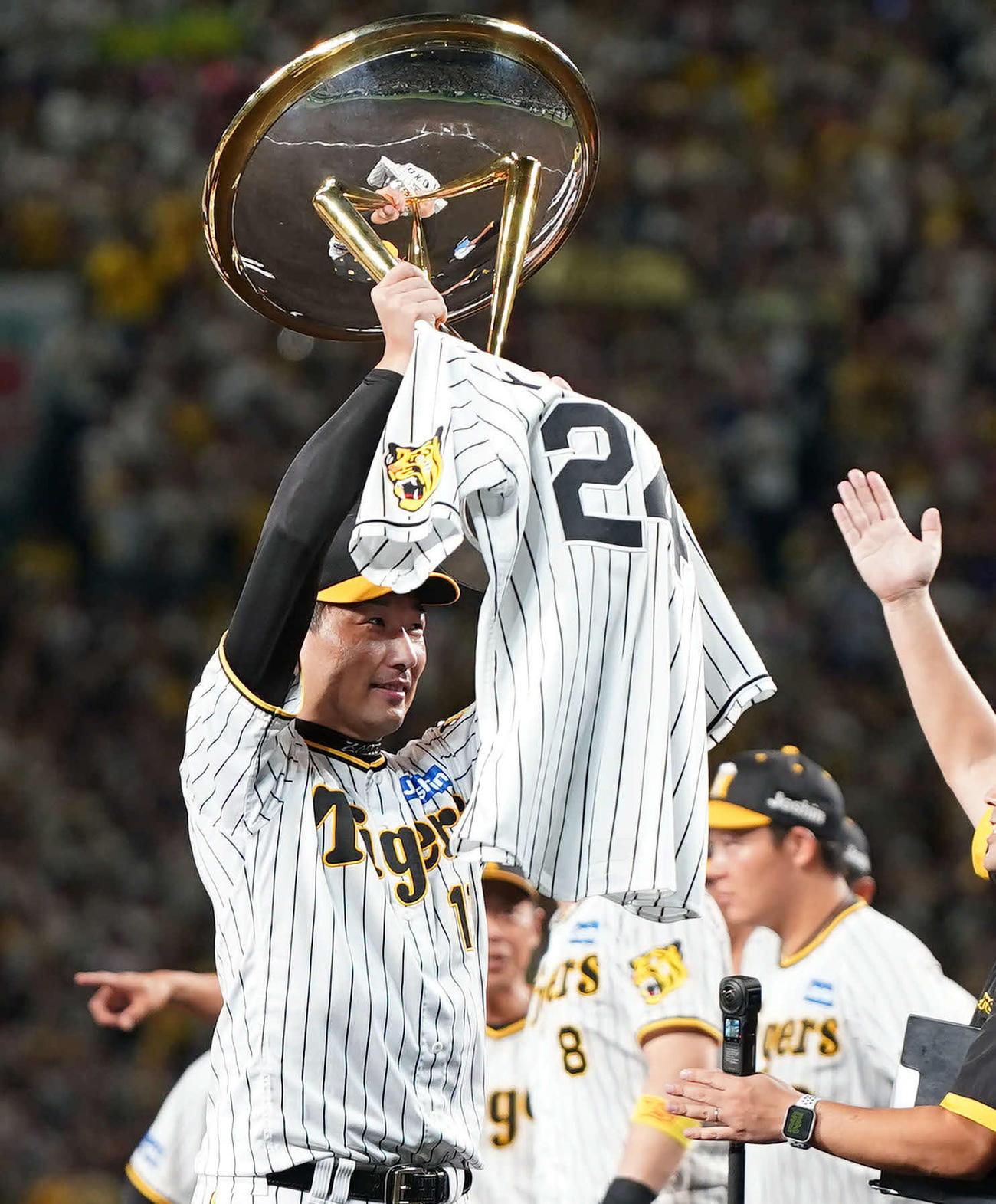 阪神対巨人　リーグ優勝を決め、優勝杯といっしょに故横田慎太郎さんのユニホームを掲げる岩崎（撮影・狩俣裕三）
