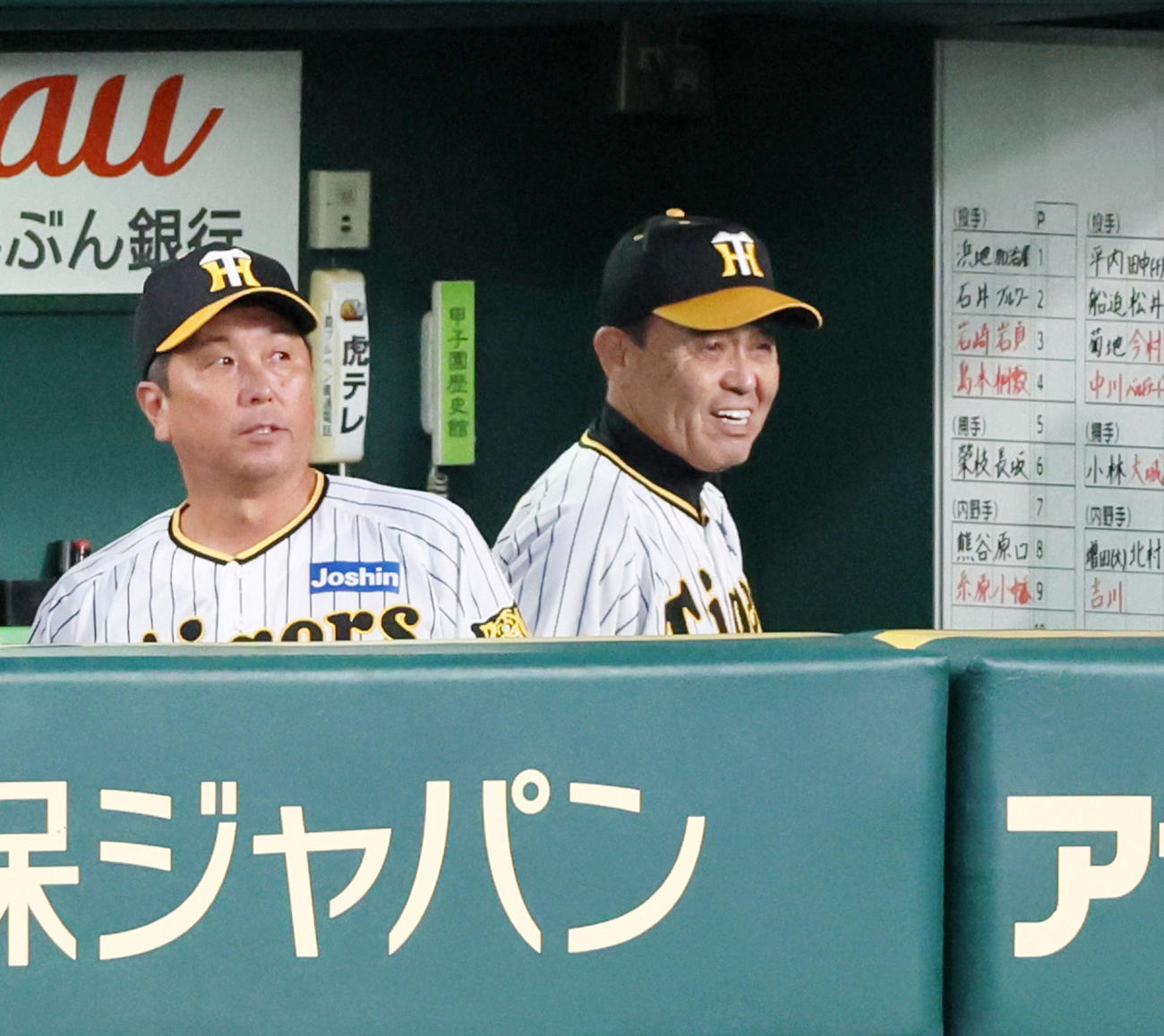 阪神対巨人　1回裏を終えベンチで白い歯を見せる岡田監督（撮影・加藤哉）