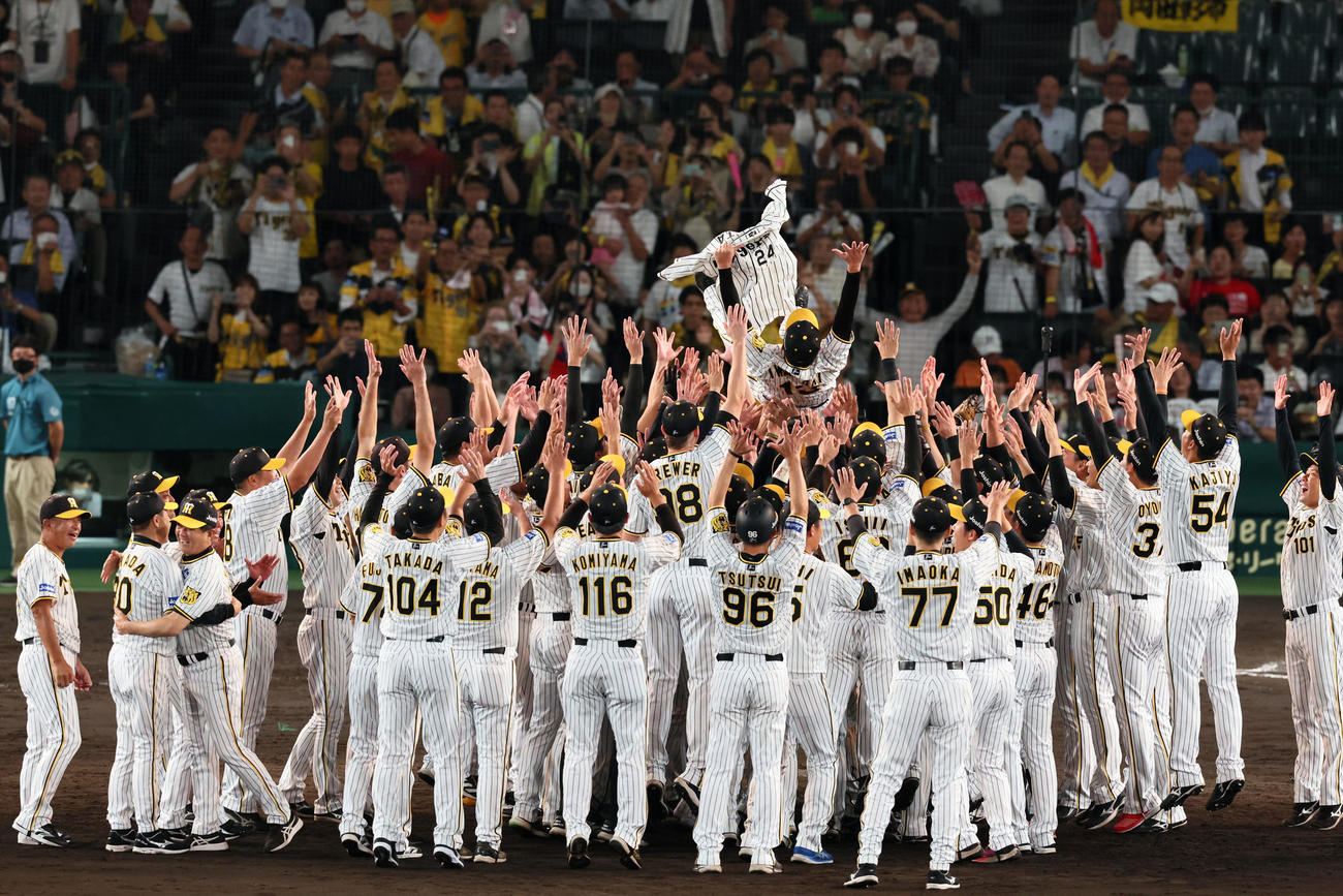阪神対巨人　リーグ優勝を故横田慎太郎氏のユニホームを手にナインから胴上げされる岩崎（撮影・加藤哉）