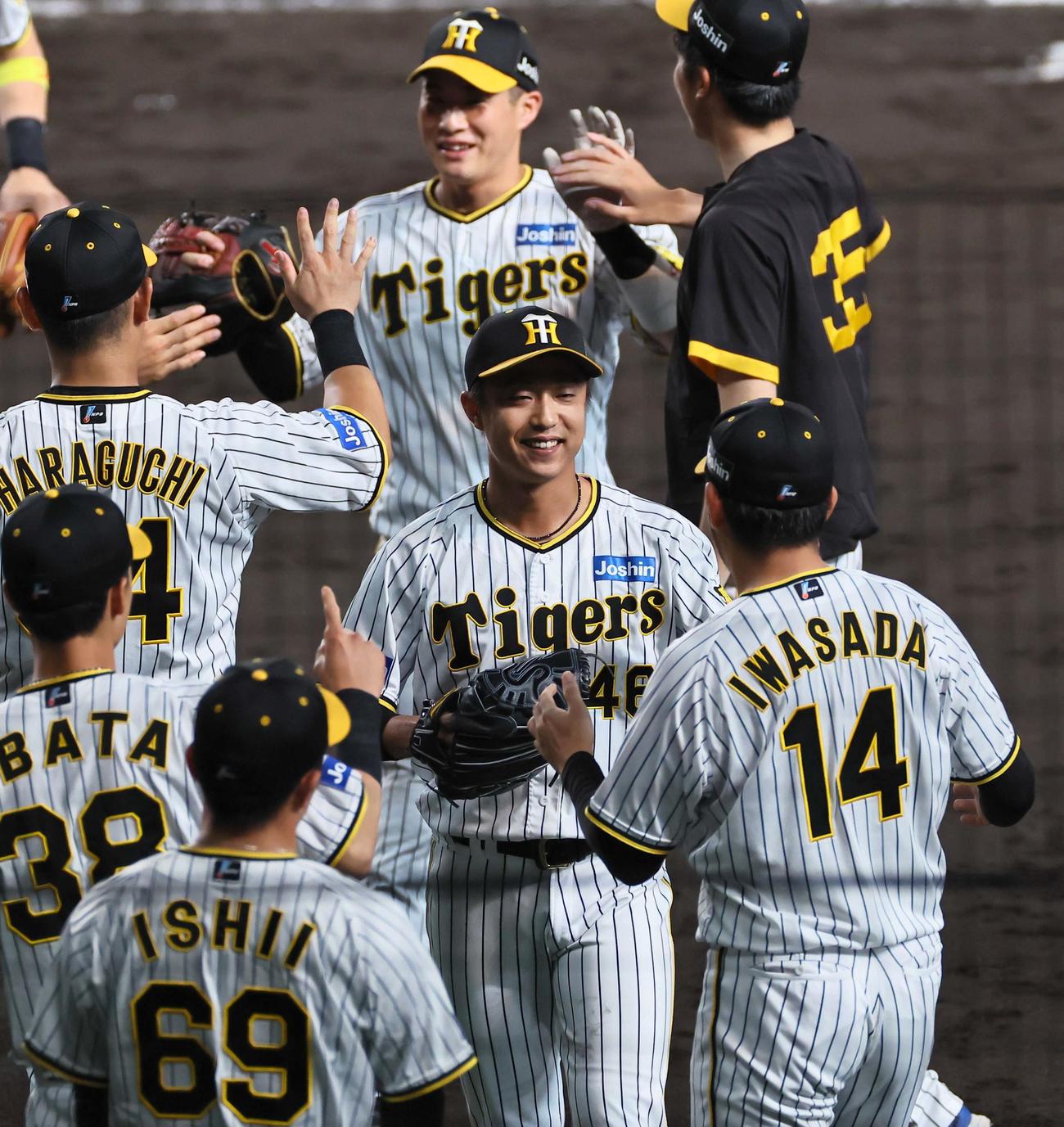 阪神対巨人　8回表を抑えた島本（中央）は岩貞（右）の出迎えに笑顔を見せる（撮影・上田博志）