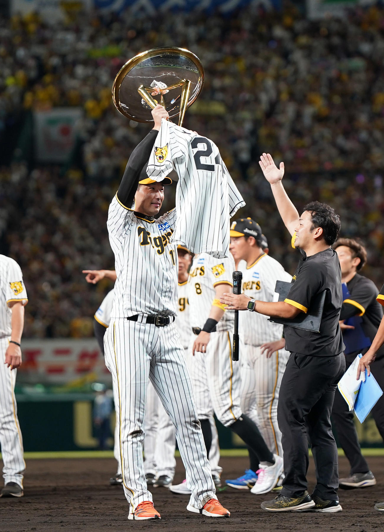 阪神対巨人　リーグ優勝を決め、優勝杯といっしょに故横田慎太郎さんのユニホームを掲げる岩崎（撮影・狩俣裕三）