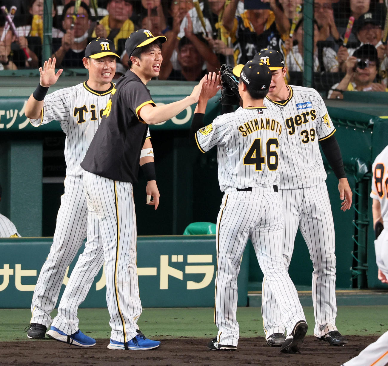 阪神対巨人　8回表巨人2死二塁、才木（左）は島本が丸を三振に仕留め笑顔で出迎える（撮影・加藤哉）