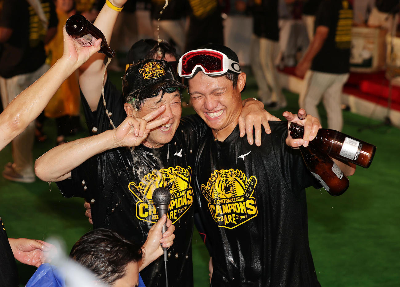祝勝会でビールを掛けられ笑顔見せる阪神平田ヘッドコーチ（左）と西純（撮影・前田充）