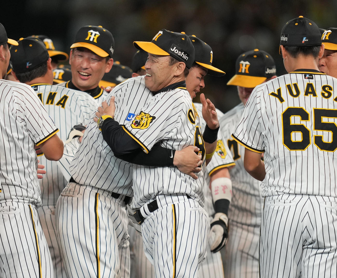 阪神対巨人　リーグ優勝を決め、抱き合い喜ぶ佐藤輝（中央左）と岡田監督（撮影・狩俣裕三）
