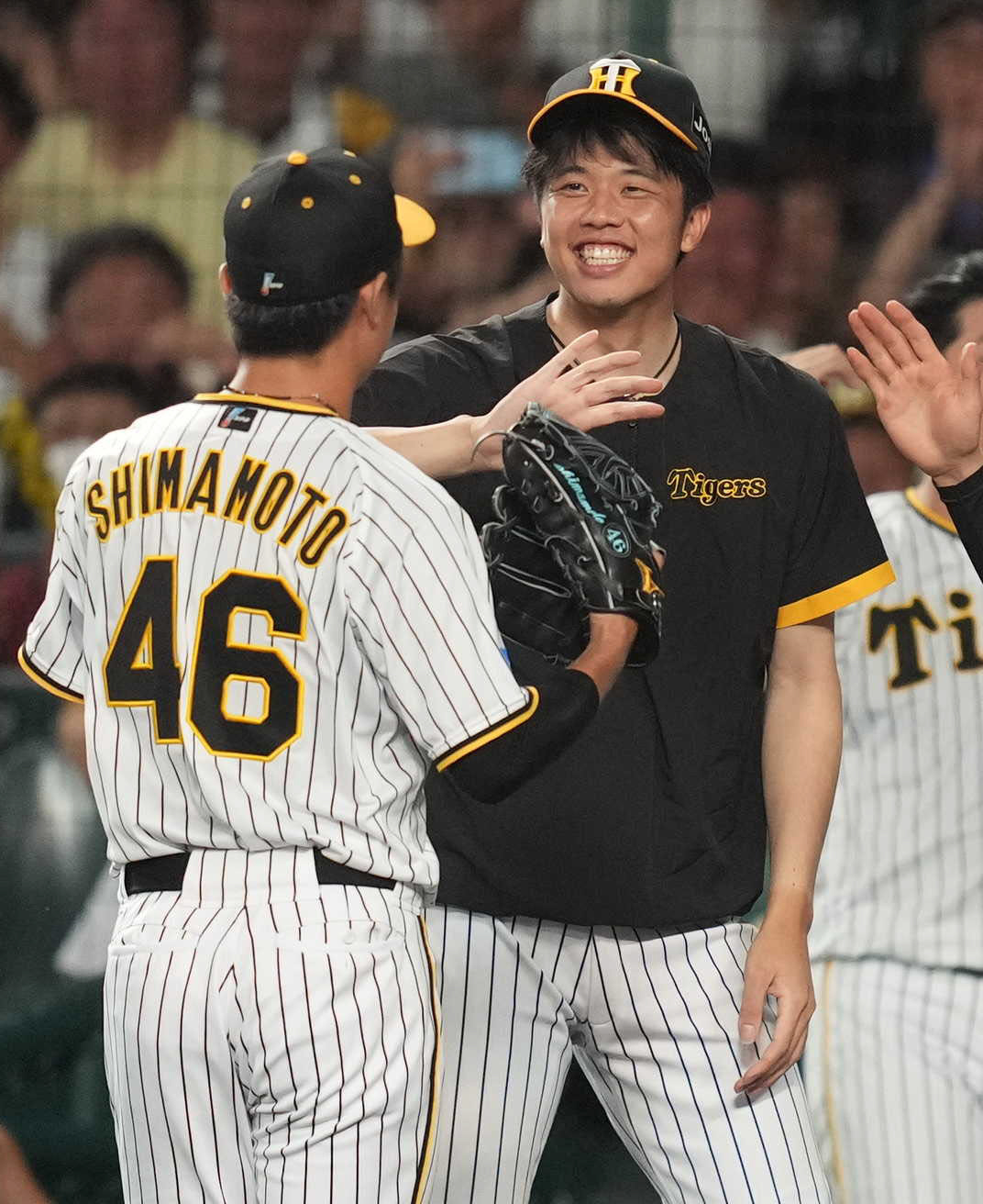 阪神対巨人　8回表を終え、島本（左）を笑顔で迎える才木（撮影・狩俣裕三）