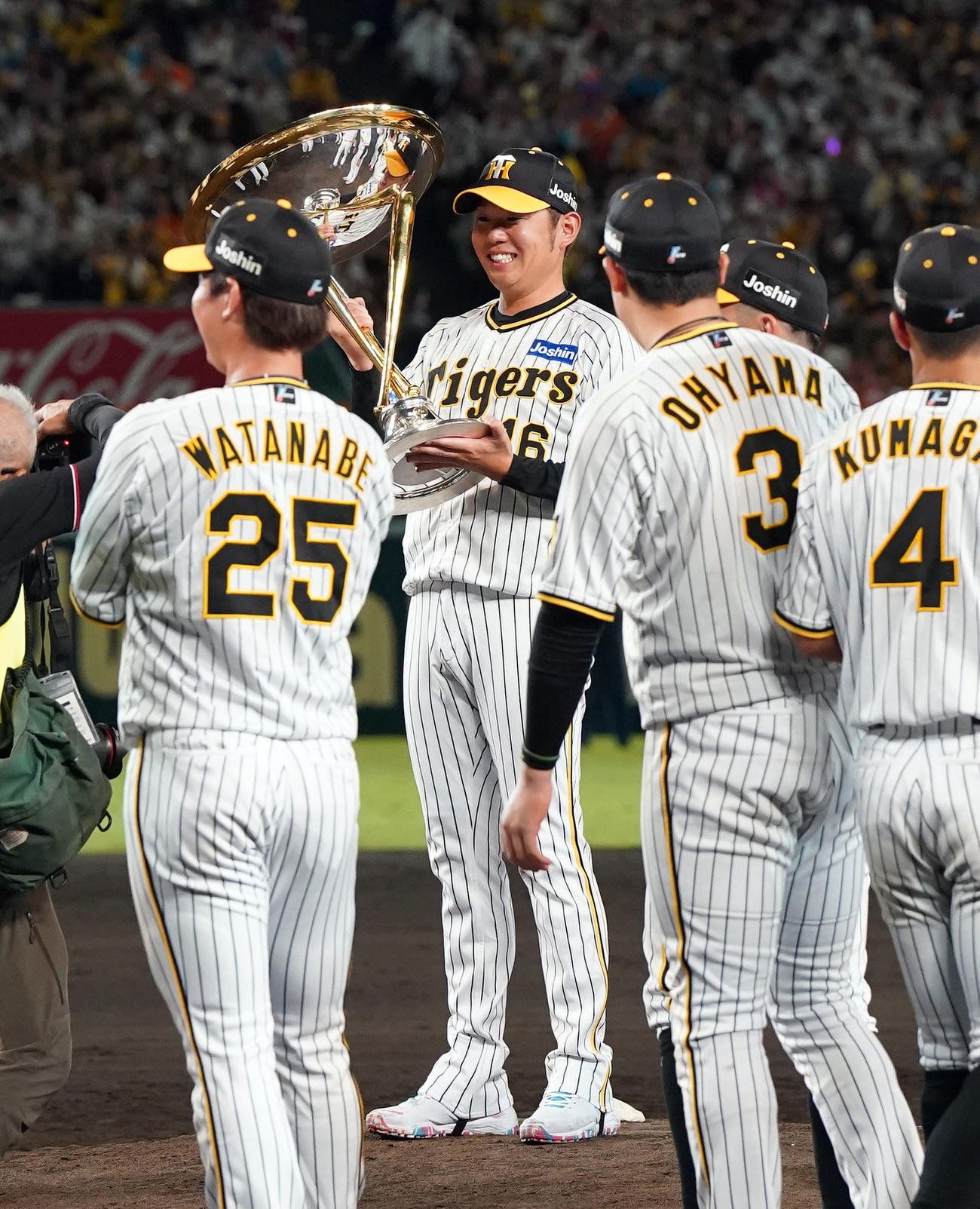 阪神対巨人　リーグ優勝を決め、優勝杯を持ち、マウンドで記念撮影をする西勇（中央）（撮影・狩俣裕三）