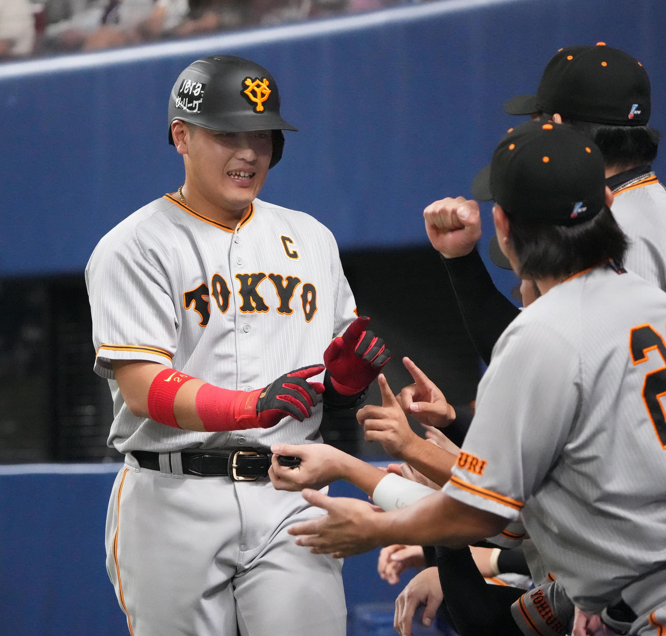 中日対巨人　4回表巨人1死、左越えソロ本塁打を放ちナインとタッチを交わす岡本和（左）（撮影・森本幸一）