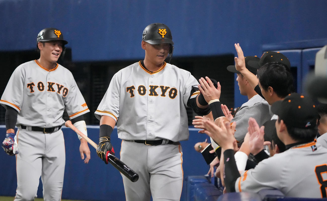 中日対巨人　2回表巨人無死一、三塁、左犠飛を放ちナインとタッチを交わす中田翔（中央）（撮影・森本幸一）
