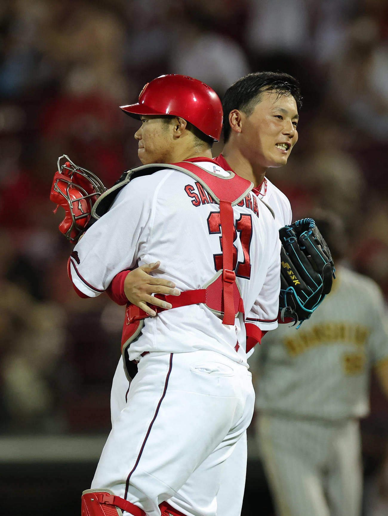 広島対阪神　阪神に勝利し広島坂倉（左）と喜ぶ栗林（撮影・前田充）