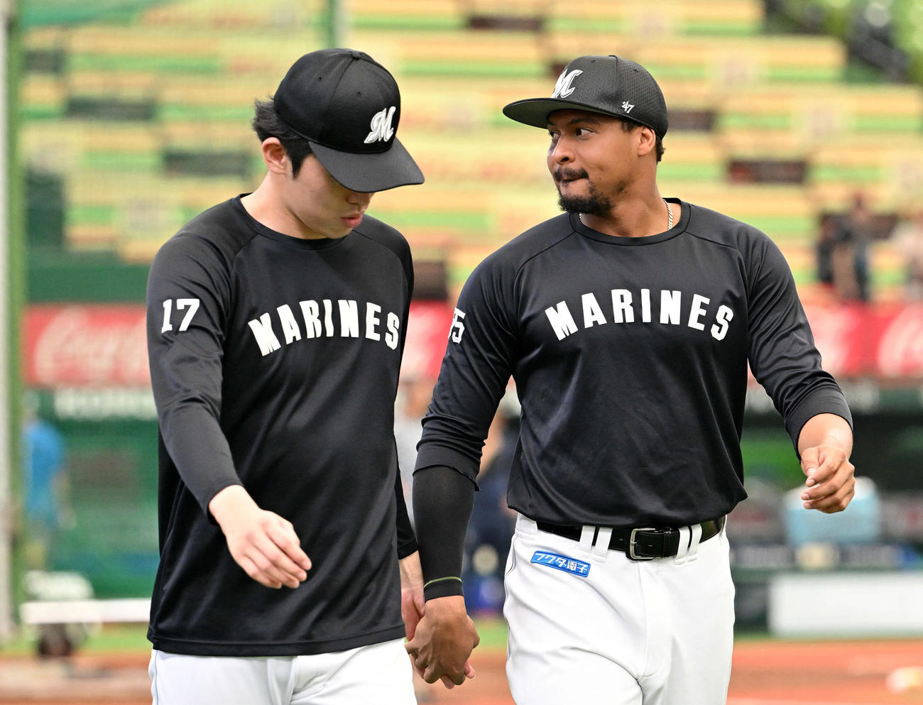 西武対ロッテ　試合前練習で手をつなぐロッテ佐々木朗（左）とペルドモ（撮影・滝沢徹郎）
