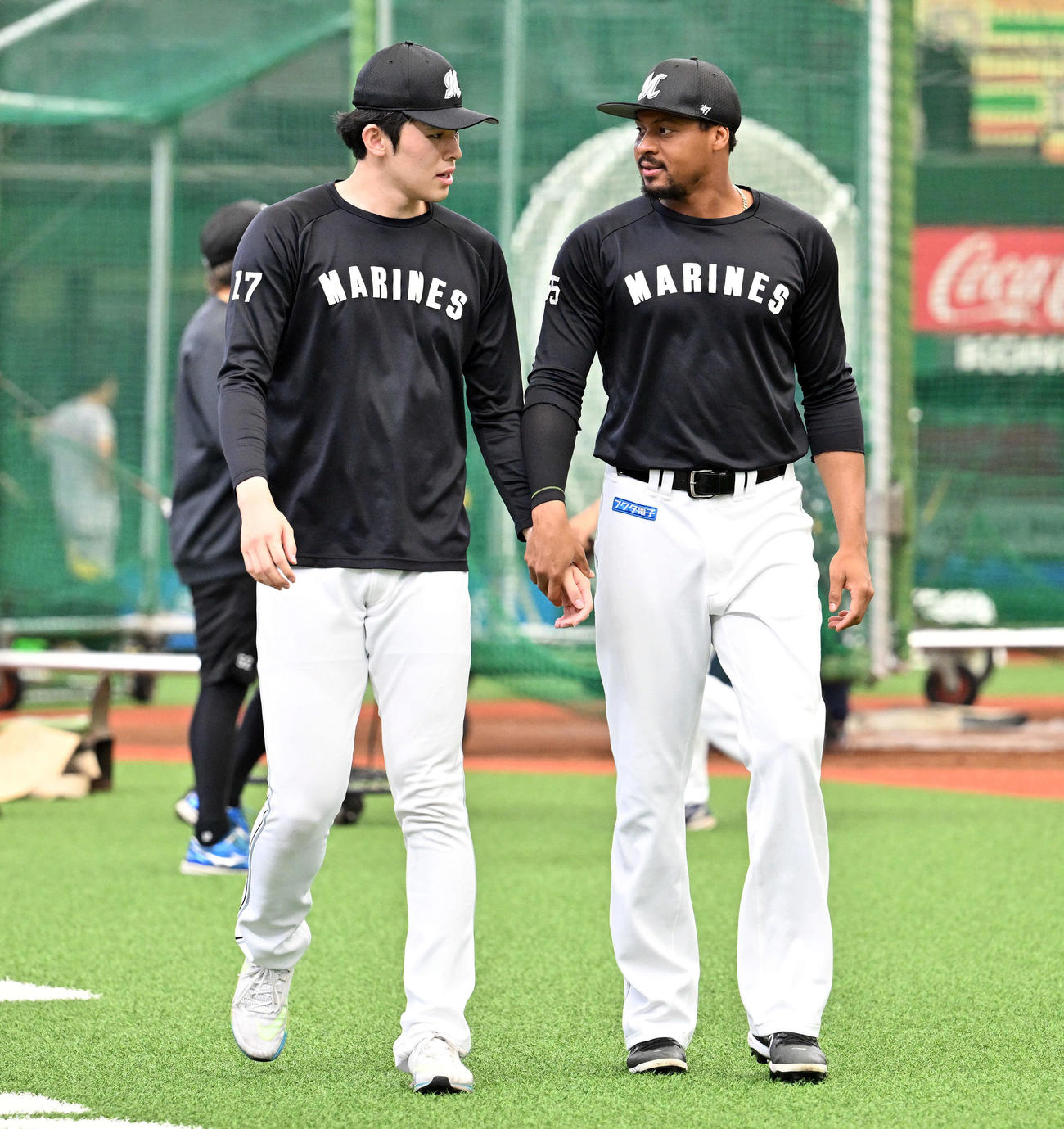 西武対ロッテ　試合前練習で手をつなぐロッテ佐々木朗（左）とペルドモ（撮影・滝沢徹郎）