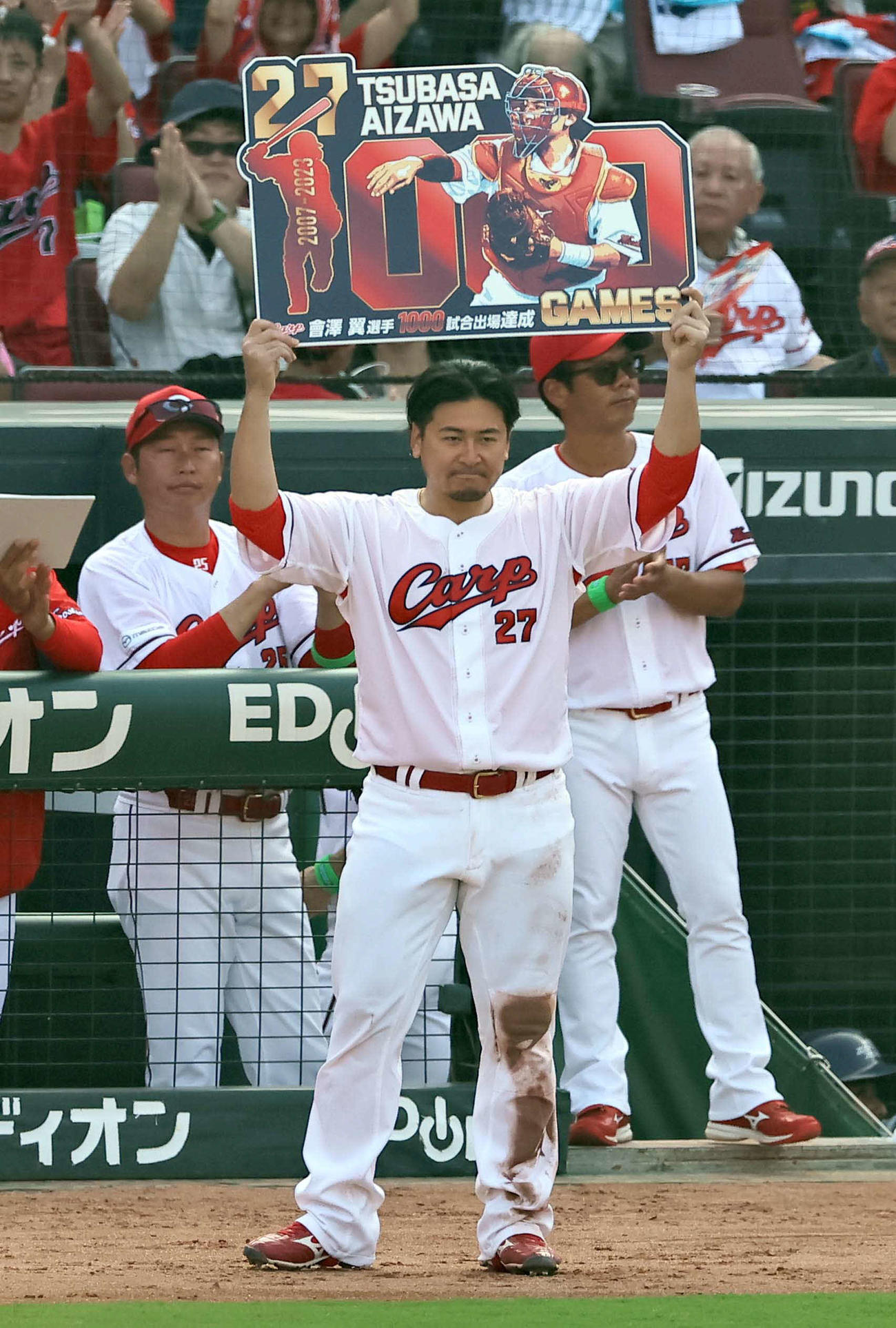 広島対阪神　1000試合出場を果たした会沢は記念パネルを手に笑顔を見せる。左は新井監督（撮影・上田博志）