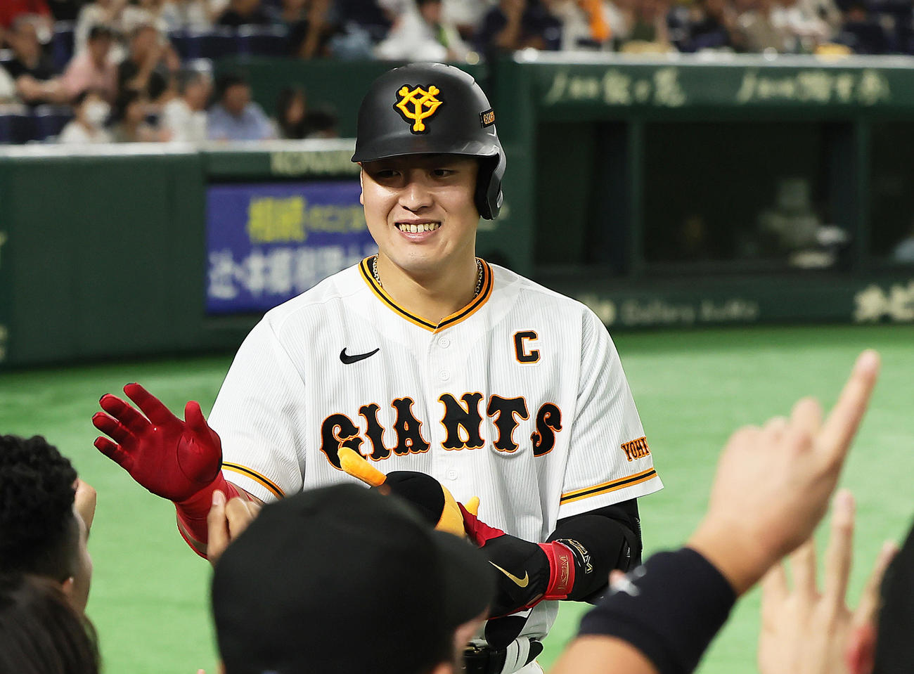 巨人対ヤクルト　6回裏巨人2死、岡本和は東京ドームでの自身通算100号本塁打を放ち笑顔でタッチを交わす（撮影・足立雅史）