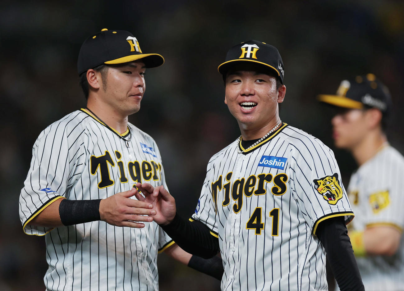 阪神対DeNA 6回表DeNA2死三塁、牧を遊ゴロに仕留め、笑顔を見せながらベンチへ戻る村上。左は迎える小野寺（撮影・前田充）