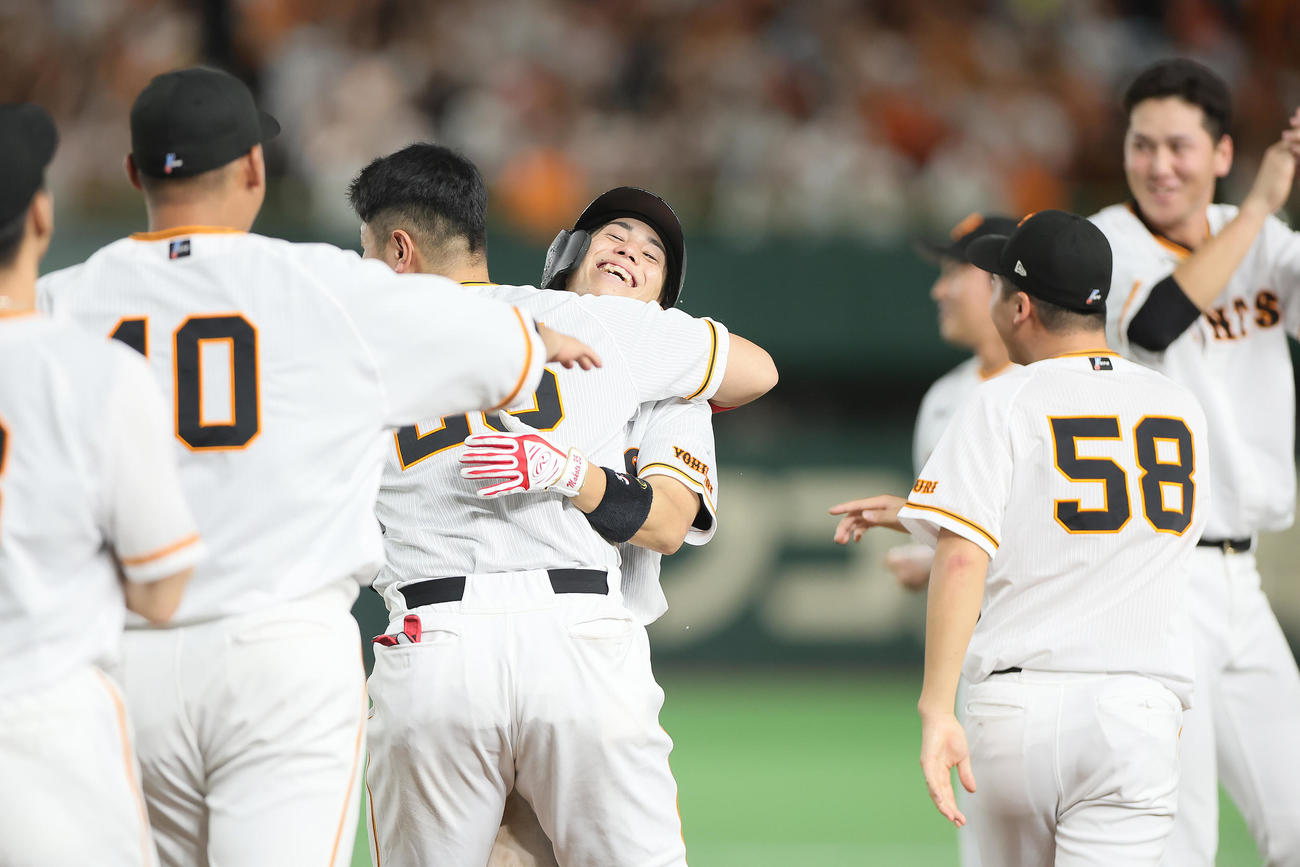 巨人対ヤクルト　9回裏巨人2死一、二塁、門脇（中央右）はサヨナラ打を放ち岡本和と抱き合い喜ぶ（撮影・足立雅史）