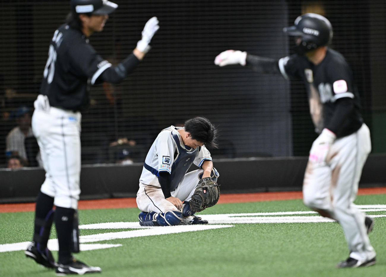 西武対ロッテ　12回表ロッテ2死三塁、ボーの暴投で決勝点を献上してうつむく捕手古市（後方）（撮影・滝沢徹郎）