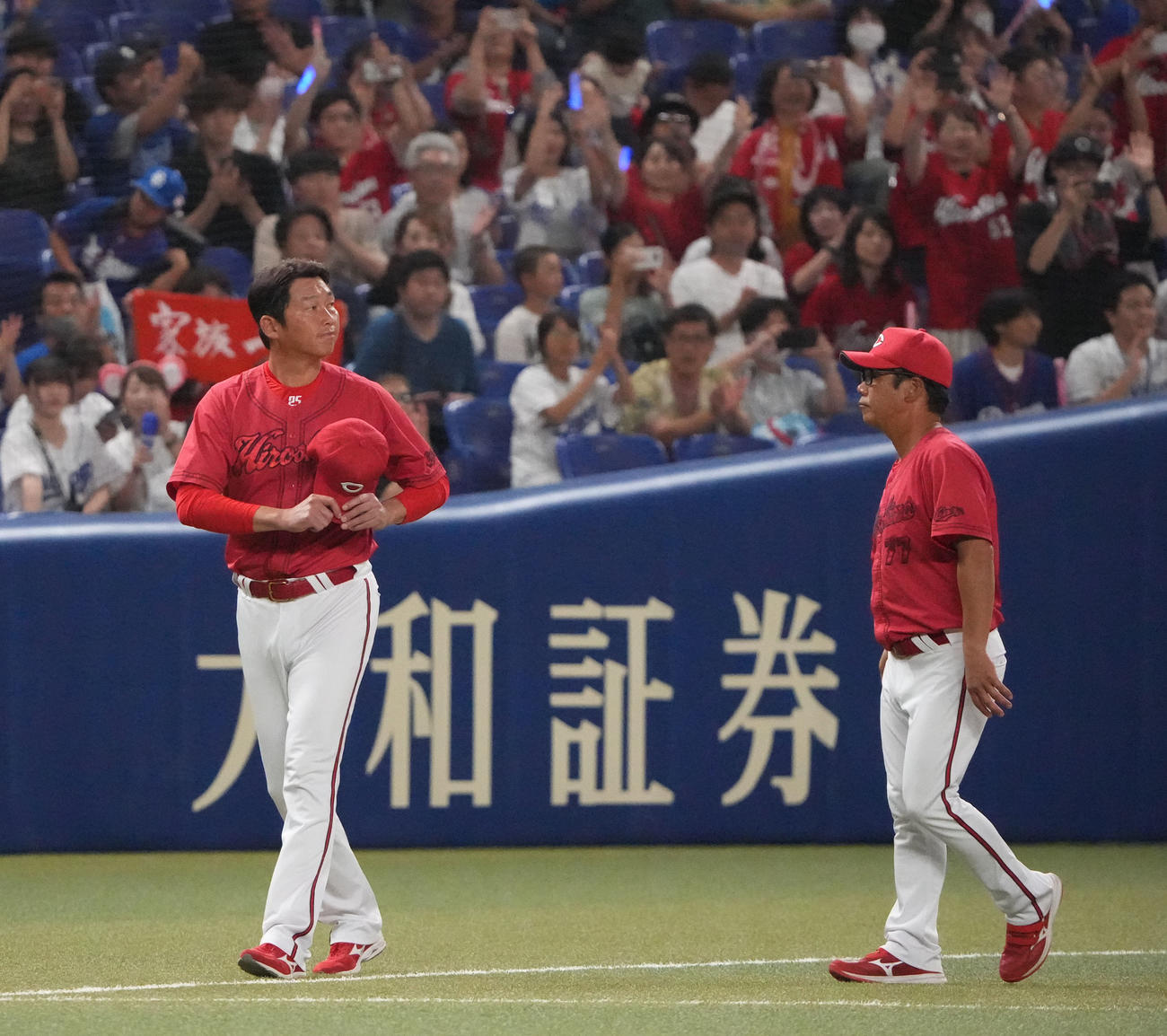 中日対広島　試合終了、レフトスタンドのファンにあいさつを終え引き揚げる新井監督（左）（撮影・森本幸一）
