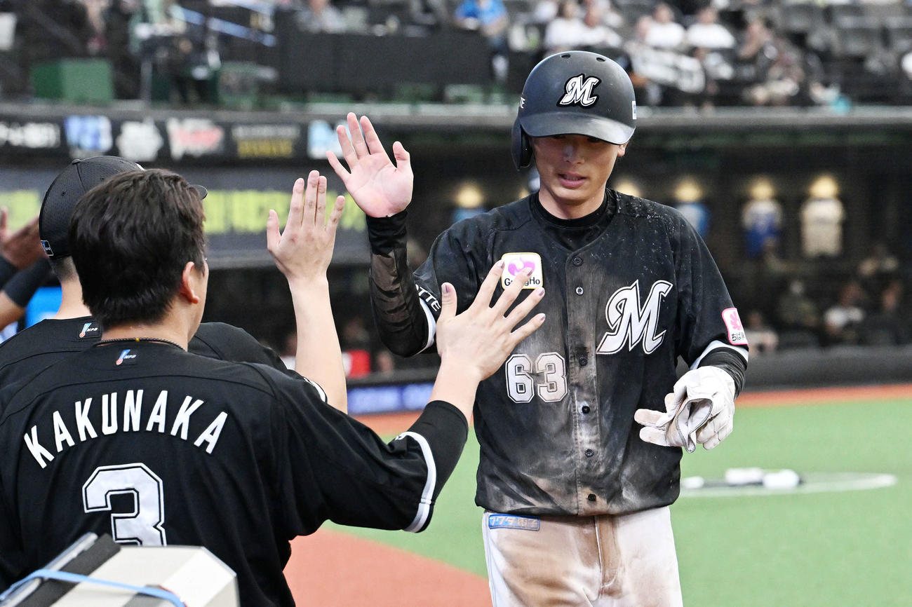 西武対ロッテ　9回表ロッテ2死二塁、安田の右前適時打で生還した代走和田（右）はチームメートとタッチをかわす（撮影・滝沢徹郎）