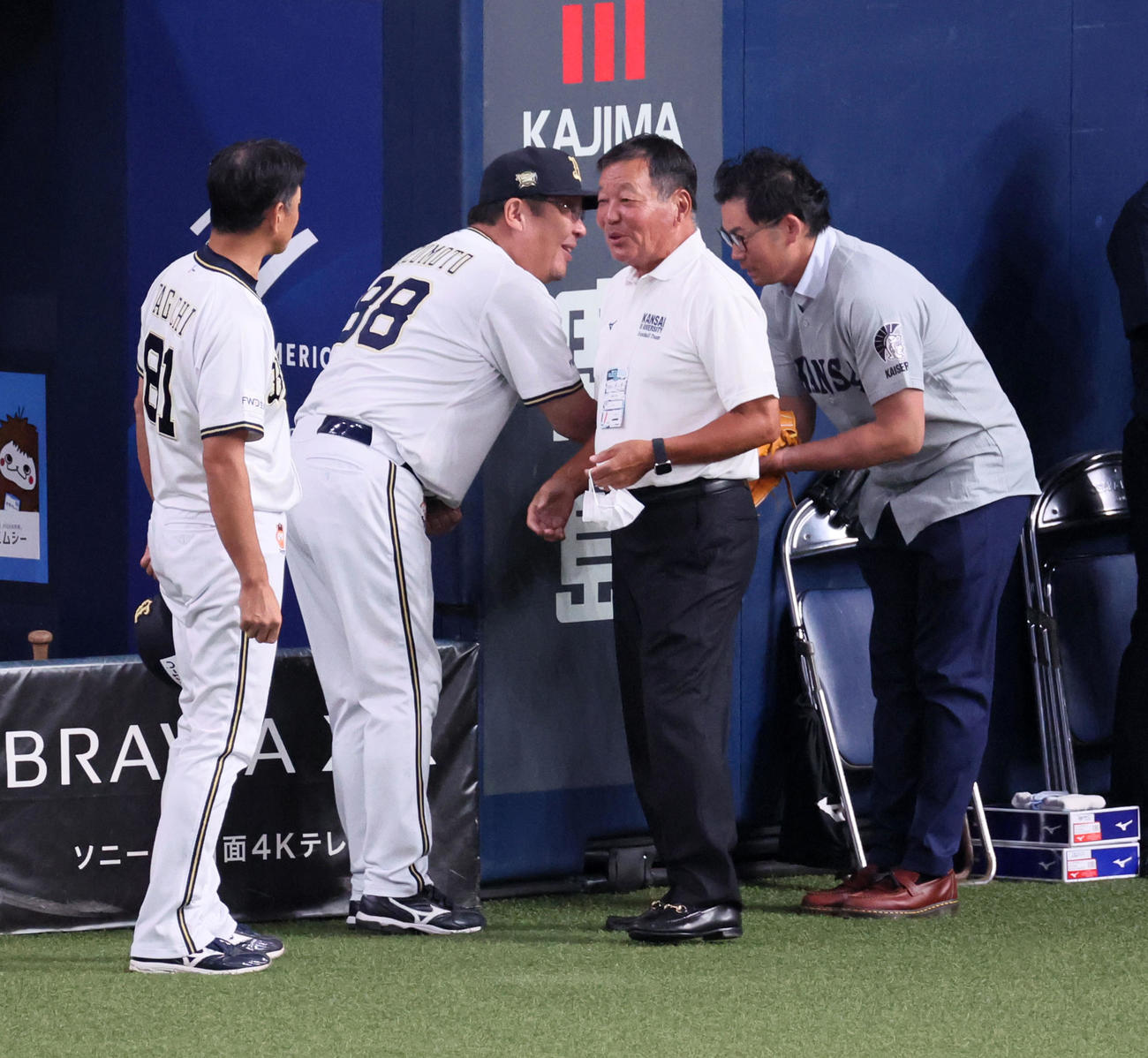 オリックス対ロッテ　水本ヘッドコーチとあいさつする関西大OBの山口氏。右は岩田氏（撮影・加藤哉）