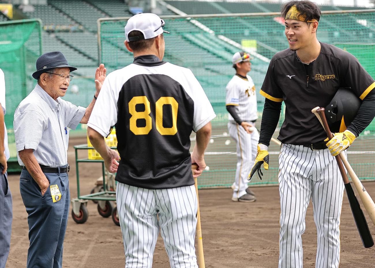 甲子園球場を訪れた吉田氏（左）は佐藤輝（右）岡田監督と話をする（撮影・上田博志）