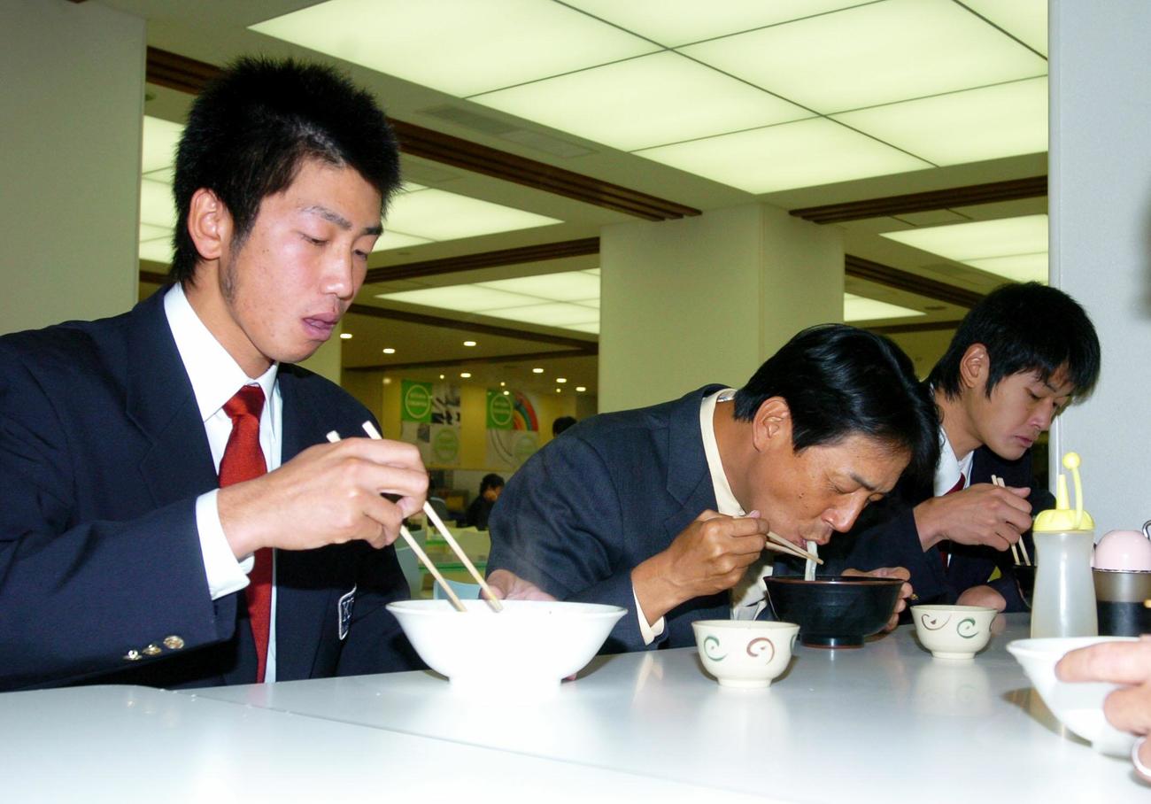 2004年11月、近大に指名挨拶に訪れ学生食堂で4巡目指名の藤田一也（左）,5巡目指名の岸本秀樹（右）とともにうどんをすする横浜ベイスターズ牛島新監督（中）