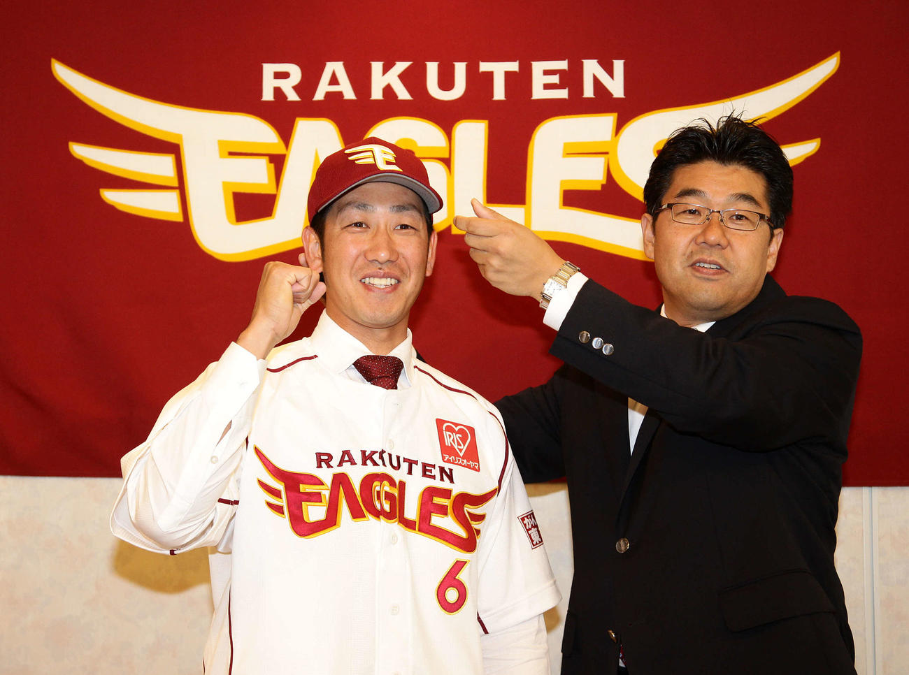 2012年6月26日、楽天入団会見で加藤チーム統括本部長（右）から帽子をかぶせてもらい笑顔を見せる藤田