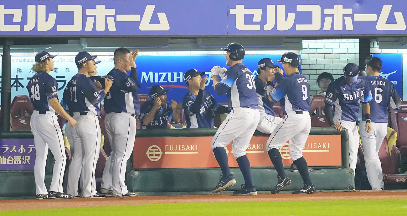 楽天対西武　3回表西武1死一塁、2点本塁打を放ちポーズを決めながらナインの出迎えを受けるマキノン（中央）（撮影・垰建太）