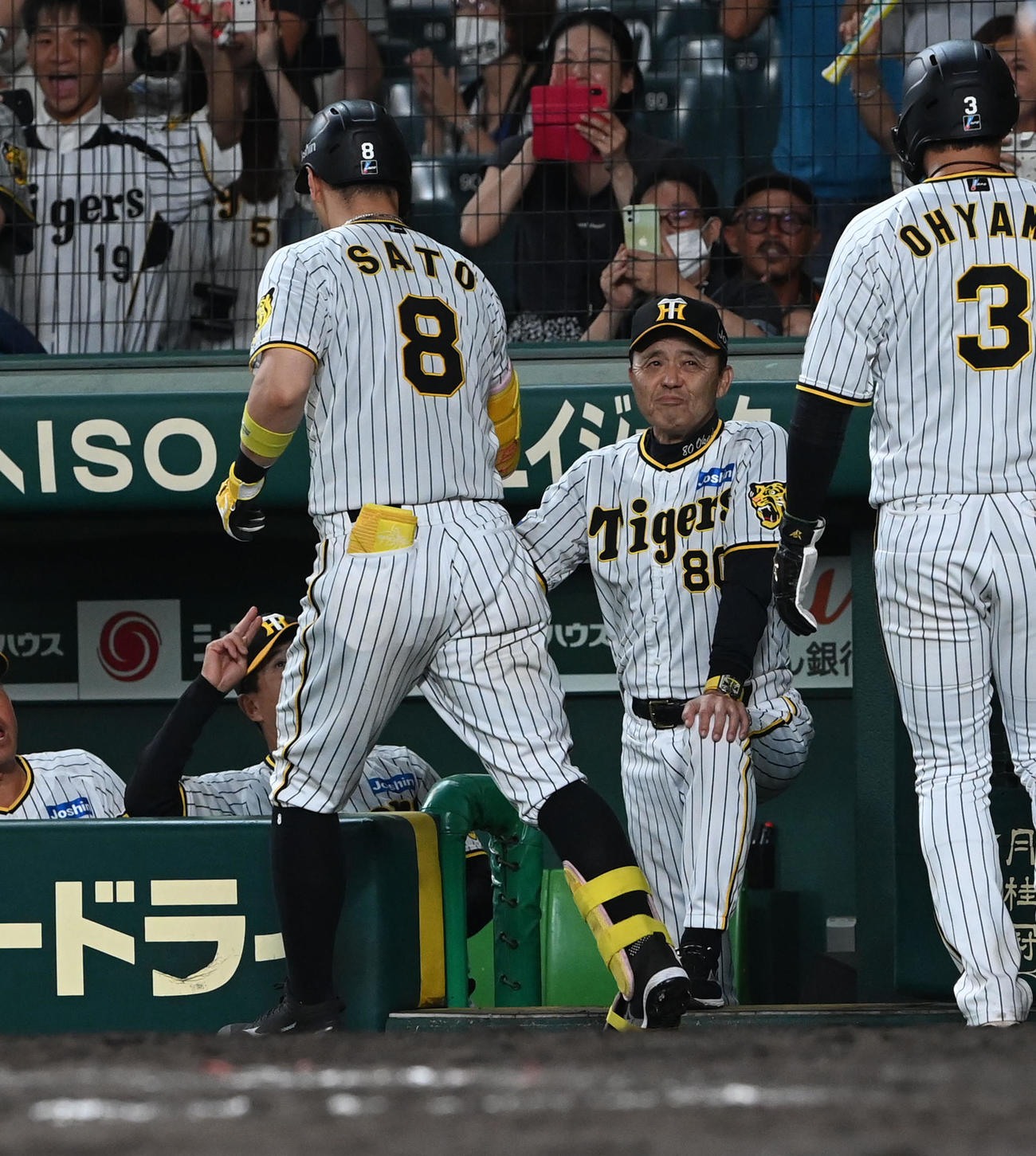 阪神対巨人　9回裏阪神無死二塁、右越え2点本塁打を放った佐藤輝（左）を笑顔で迎える岡田監督（撮影・前岡正明）