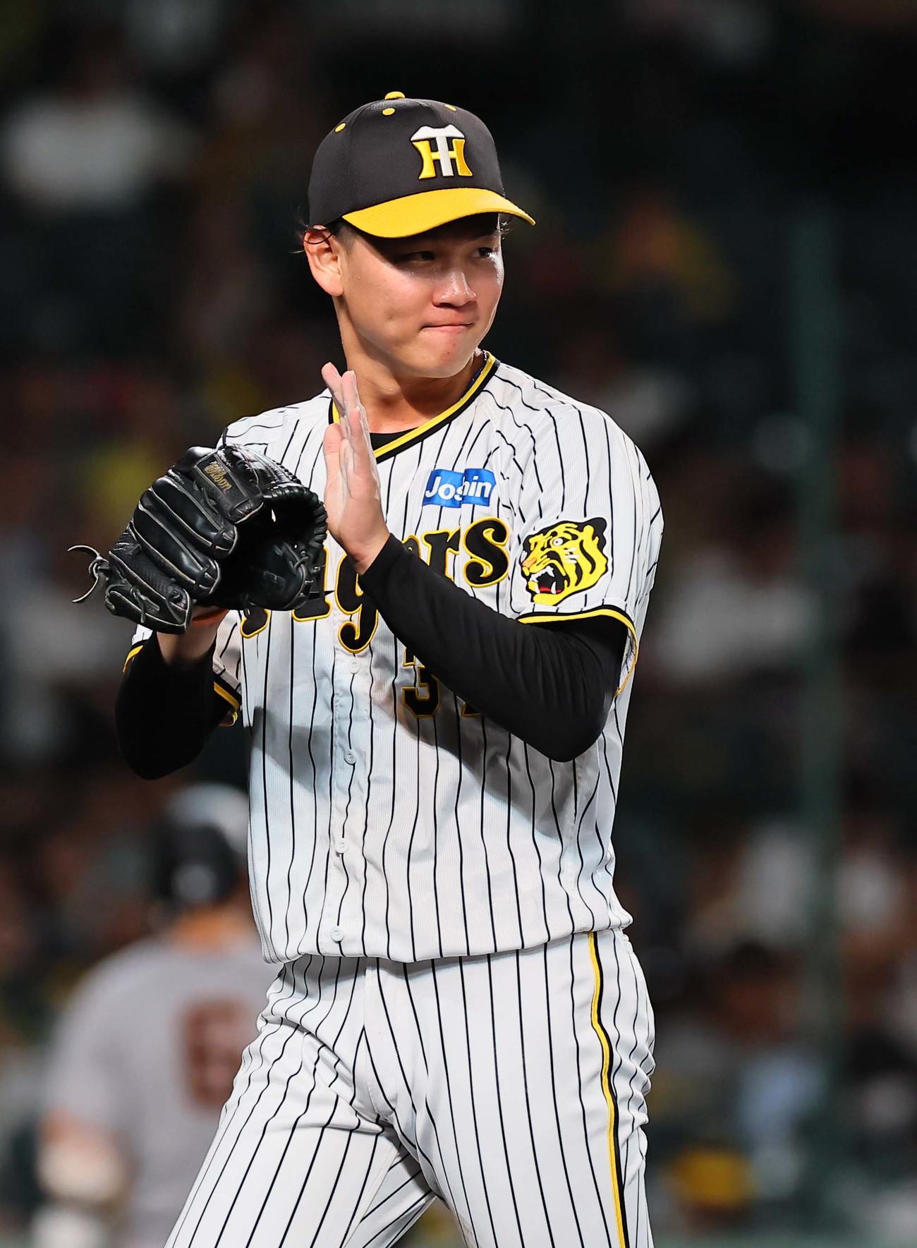 阪神対巨人　巨人打線を無失点に抑えた及川はグラブをたたきながらベンチに引き揚げる（撮影・上田博志）
