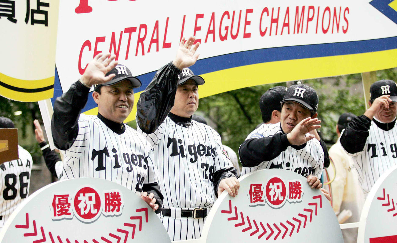 05年11月6日、大阪御堂筋で沿道の観衆に手を振る左から岡田監督、平田コーチ、正田コーチ