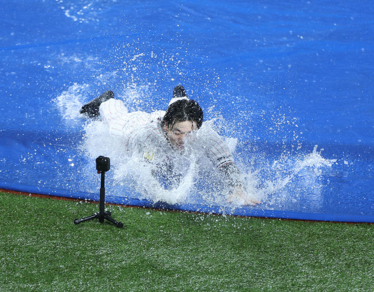 ヤクルト対阪神　　雨天中止となり、本塁へヘッドスライディングするヤクルト長岡だが勢い余ってカメラに激突する（撮影・井上学）