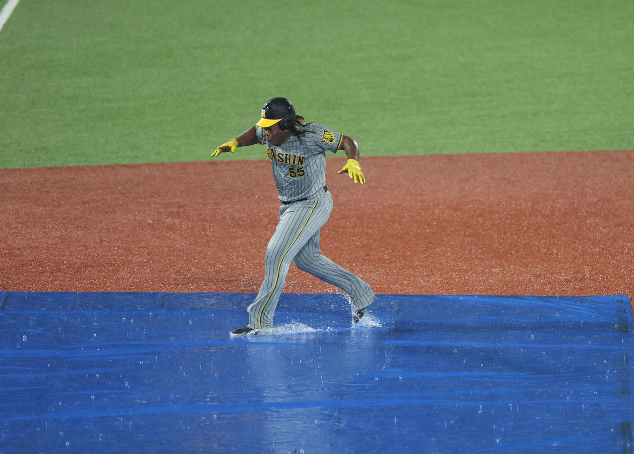 ヤクルト対阪神　雨天中止となり、阪神ミエセスはシートで転ばないように走る（撮影・井上学）