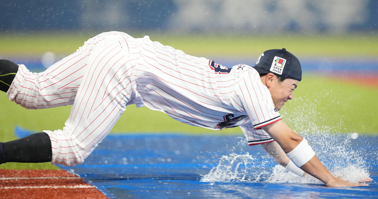 雨天中止となり、一塁へヘッドスライディングするヤクルト丸山和（撮影・鈴木みどり）